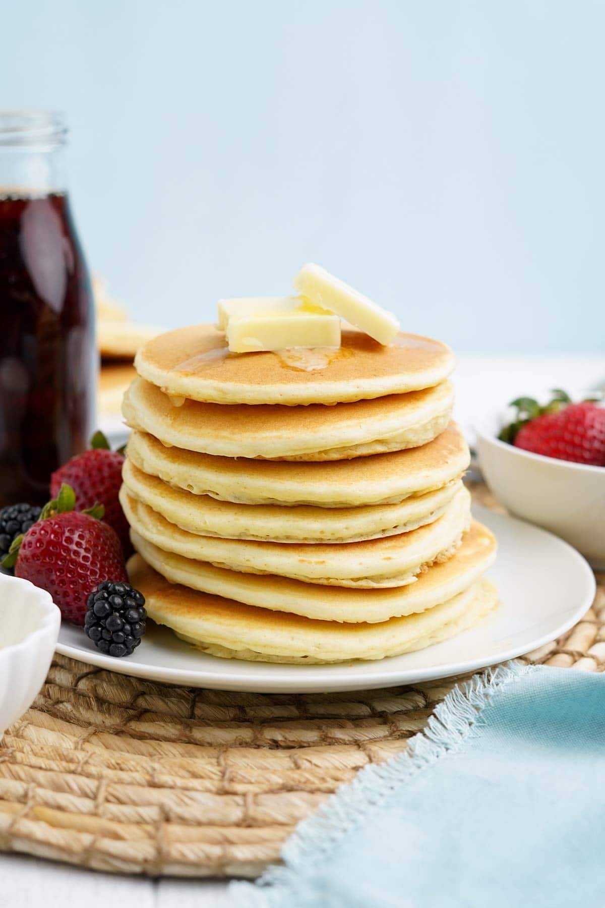 Stack of pancakes with oat milk on a plate.