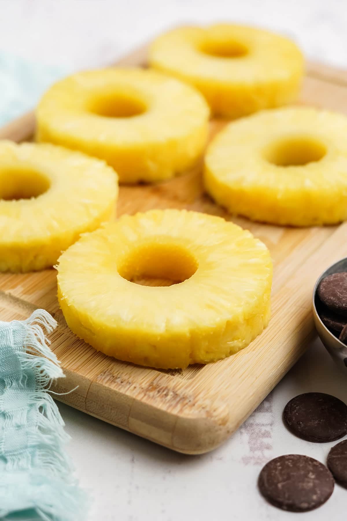 Pineapple rings laying on a cutting board.