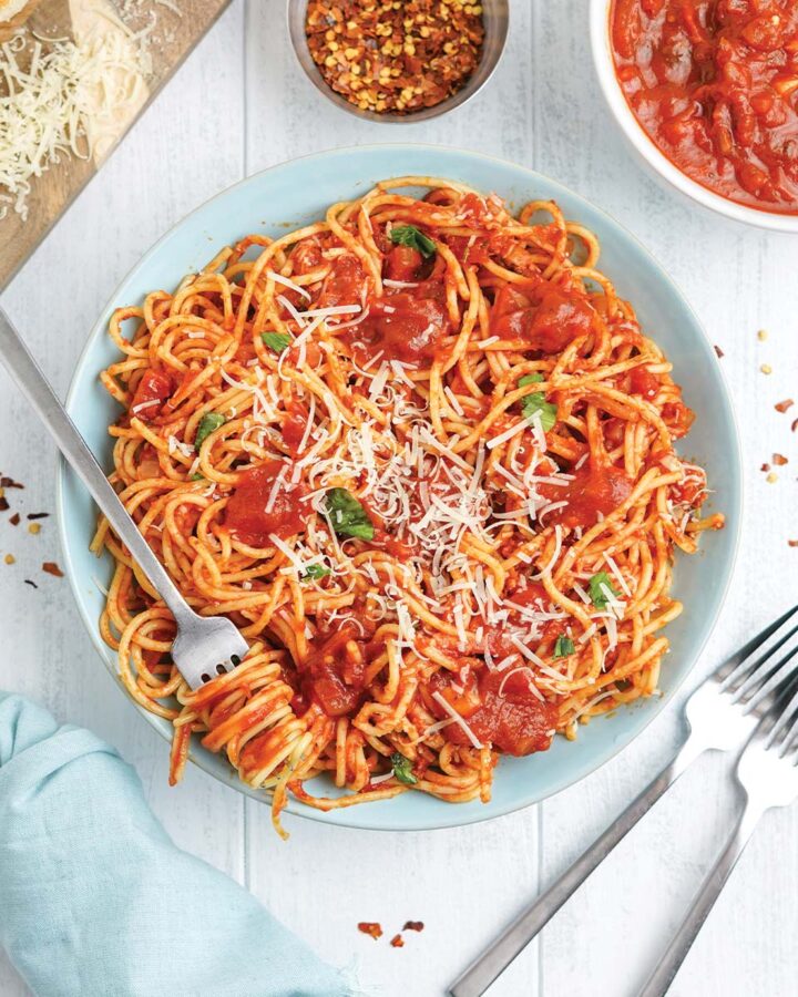 Bowl of spaghetti arrabiata with a fork twisted with pasta.
