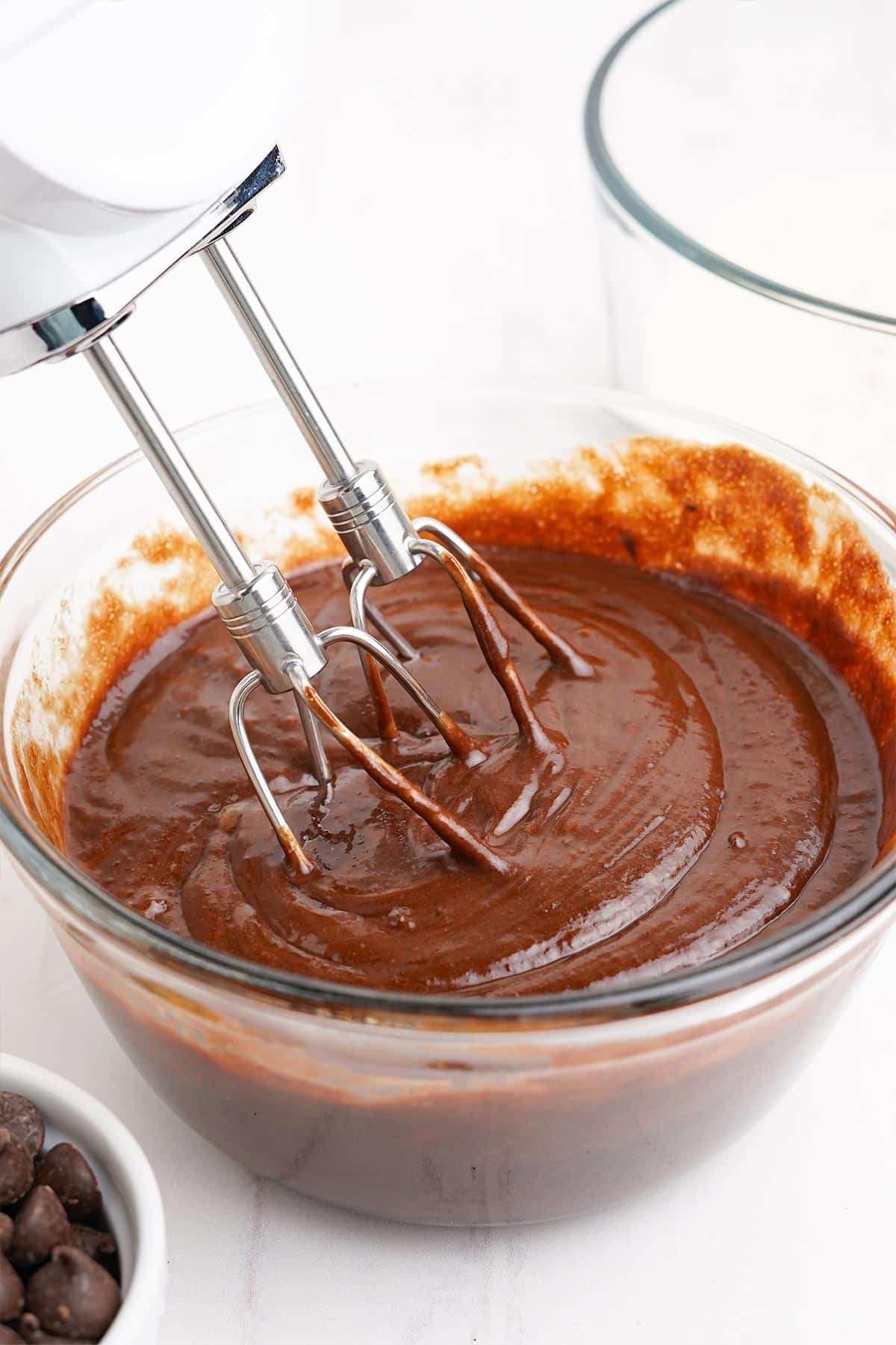 Electric mixer mixing the batter for triple chocolate muffins.