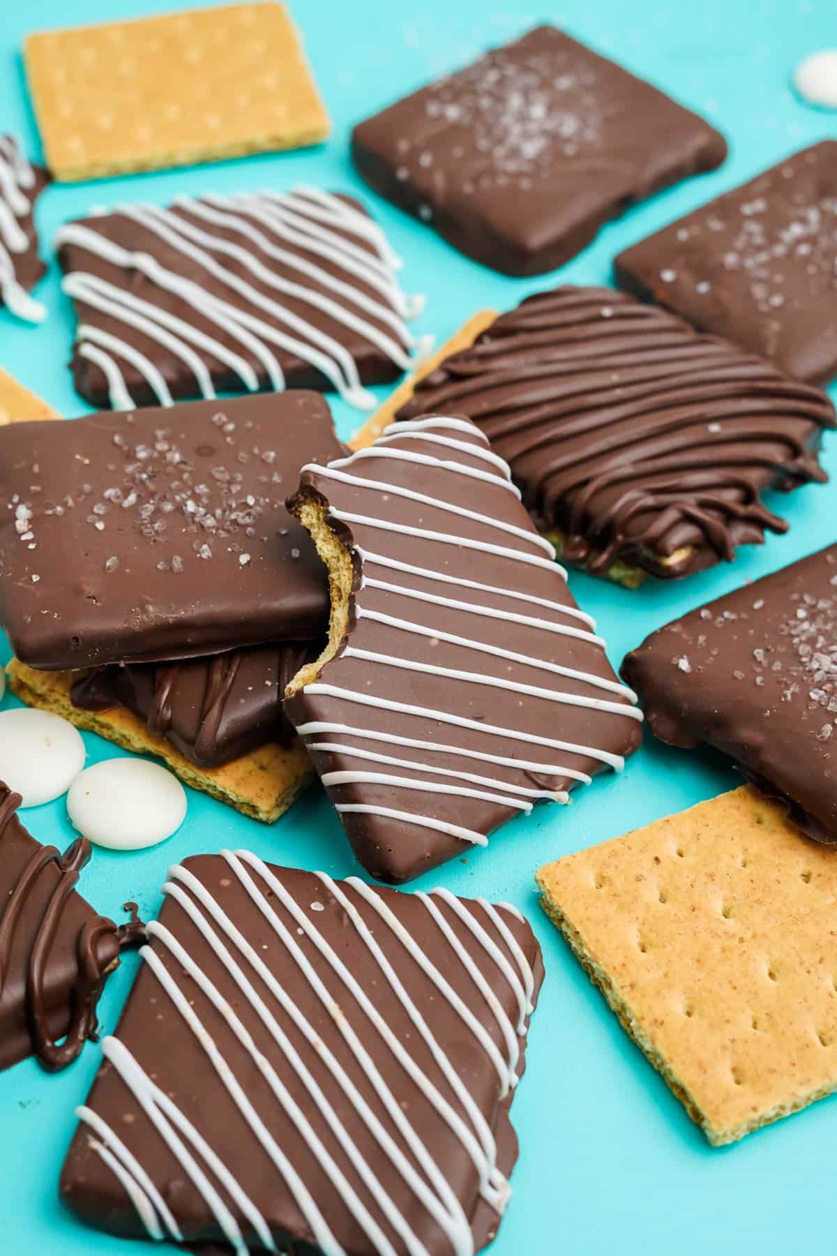 Chocolate covered graham crackers on the table, one with a bite taken.