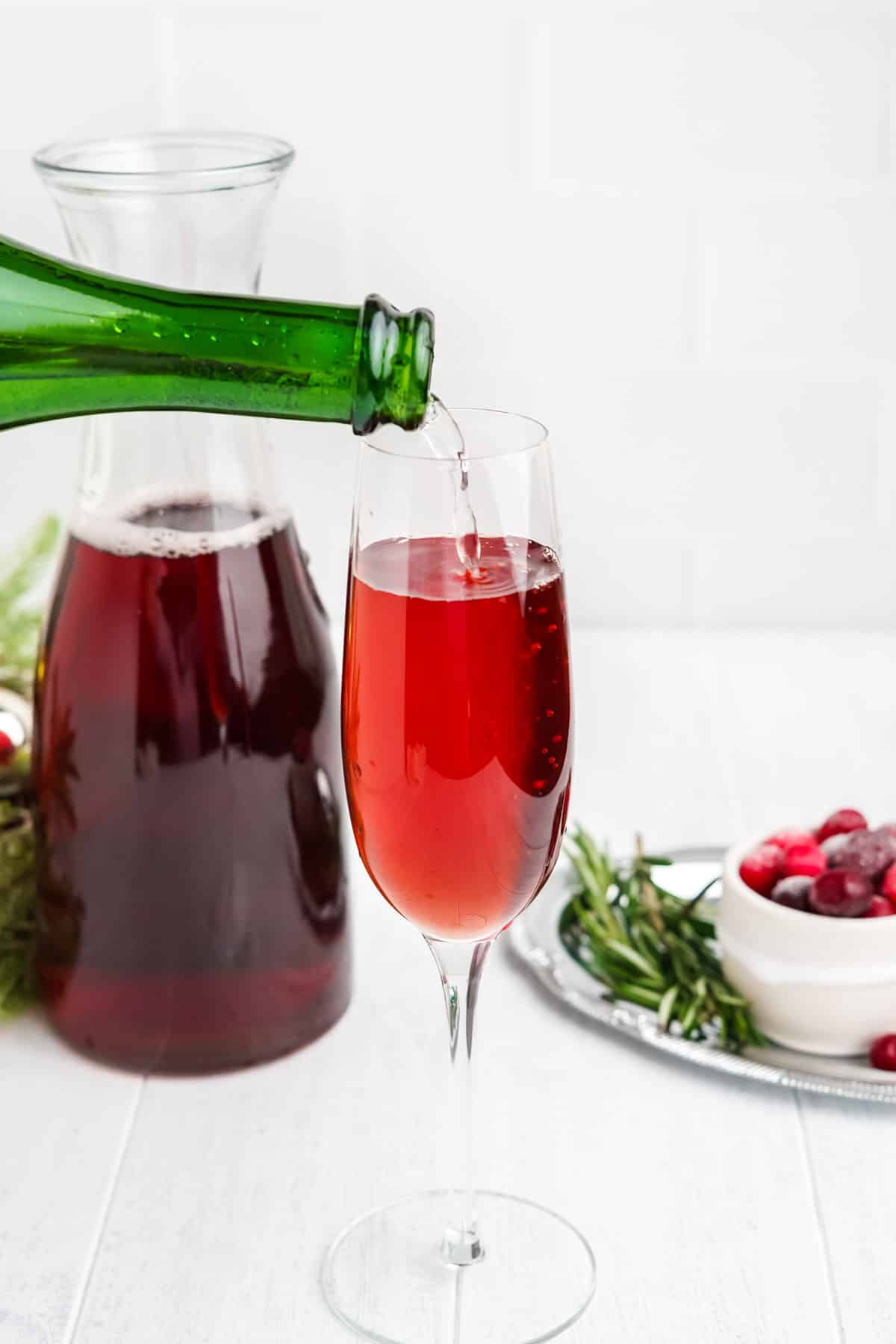 Adding the champagne on top of the cranberry juice.