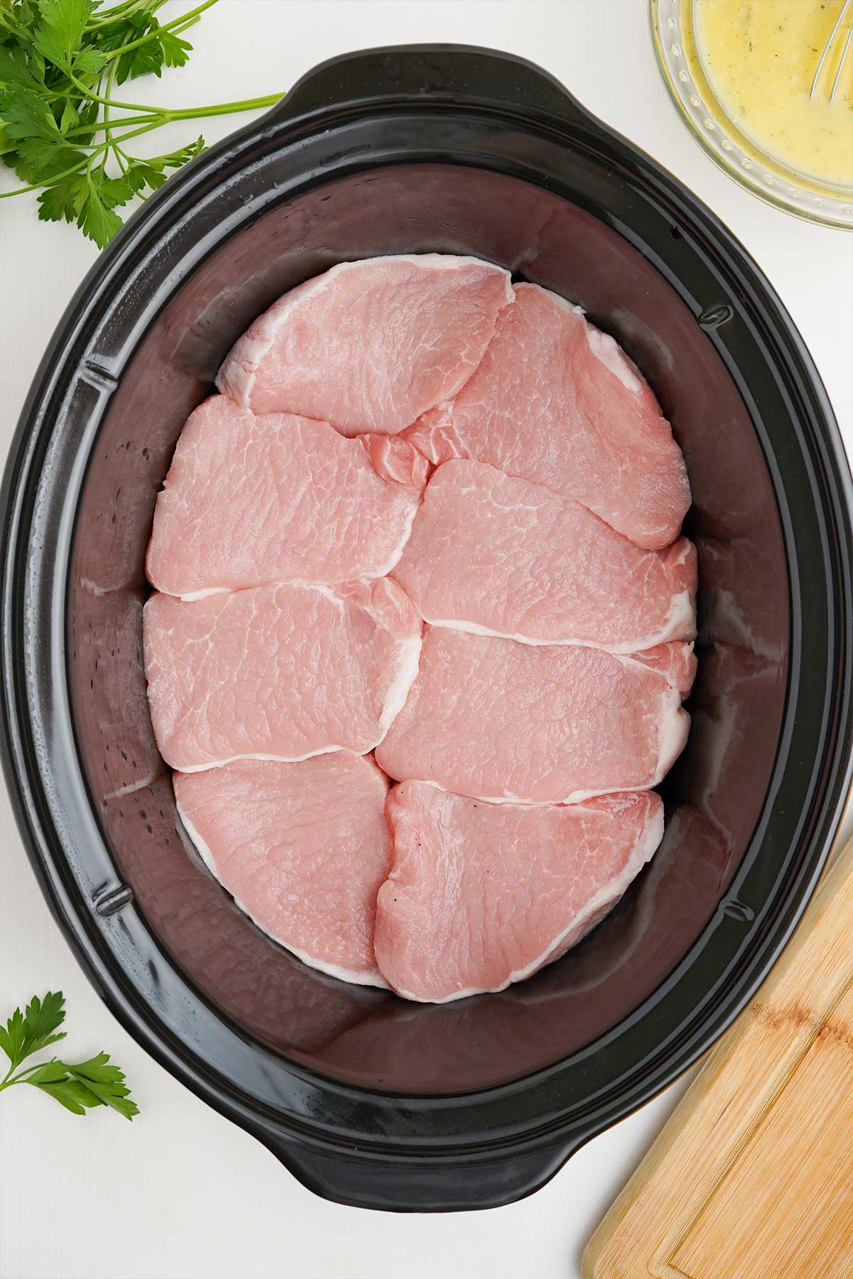 Pork chops layered in the bottom of crockpot.