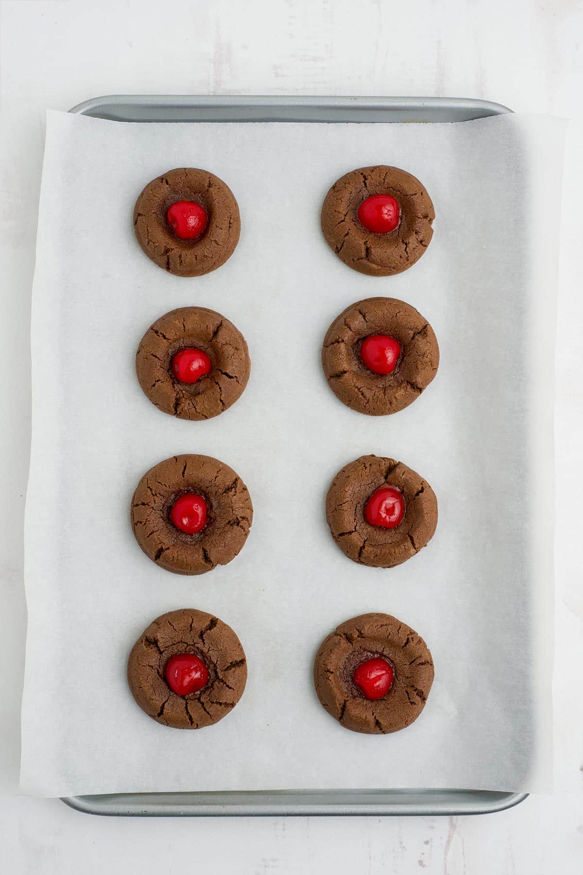 Chocolate cherry cookies on a baking tray after cooking.