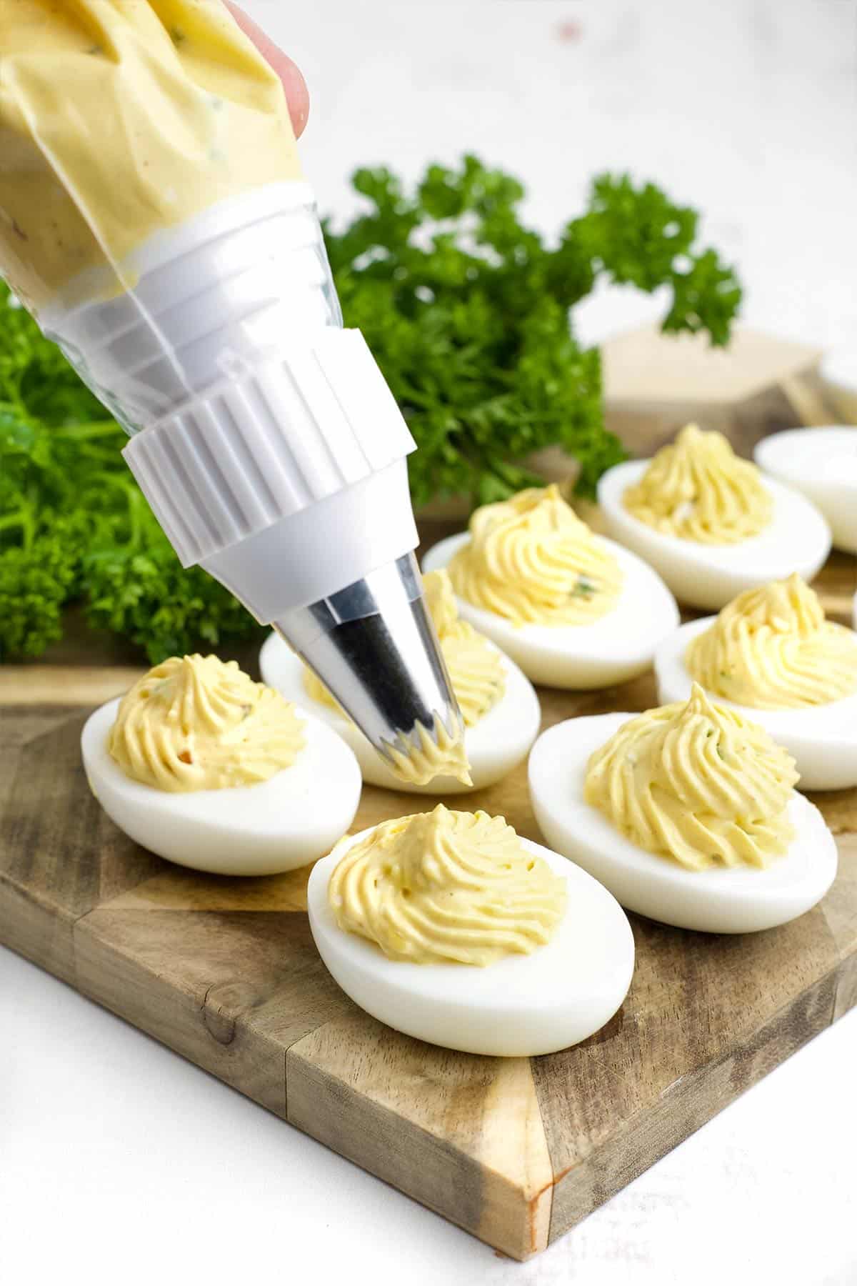 Piping the egg whites with the spicy egg filling.