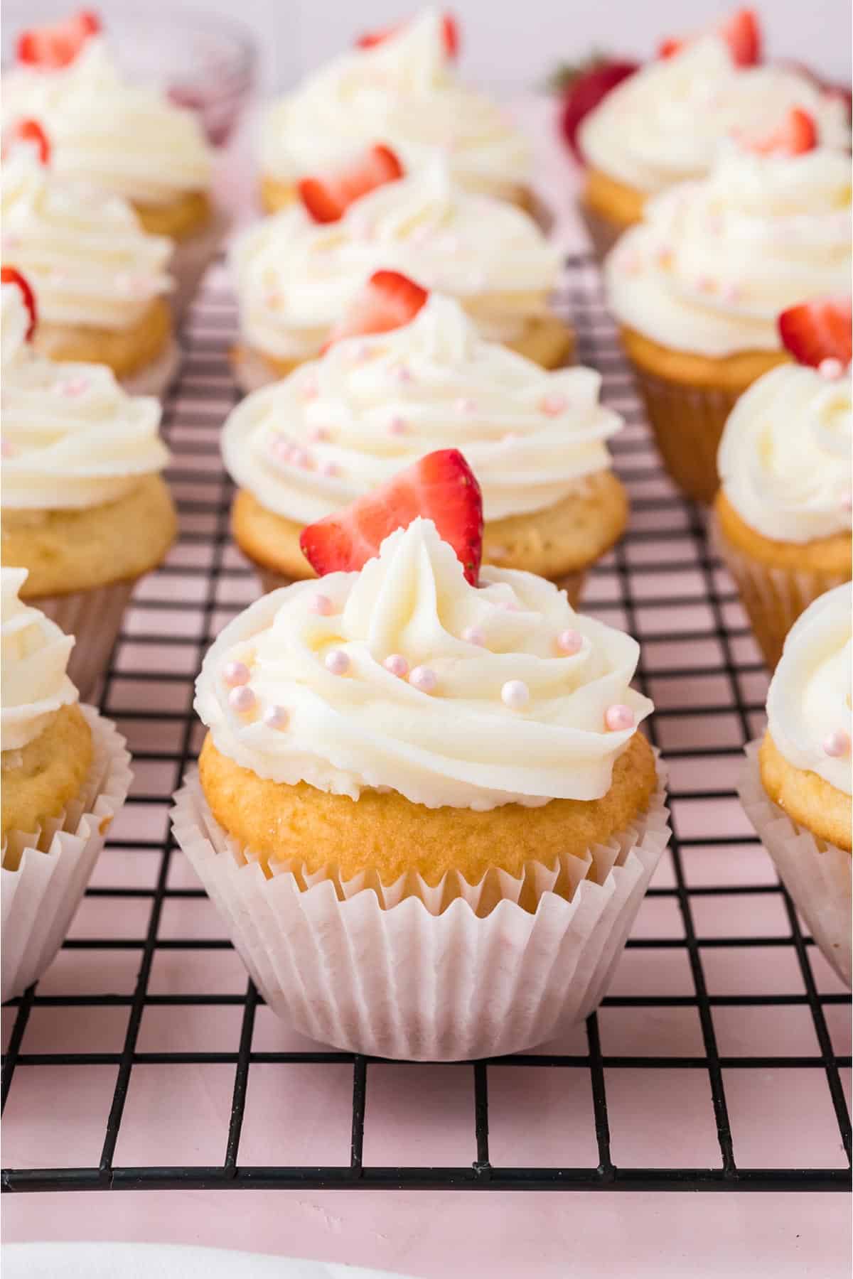Strawberry cupcakes on a wire rack ready to eat.