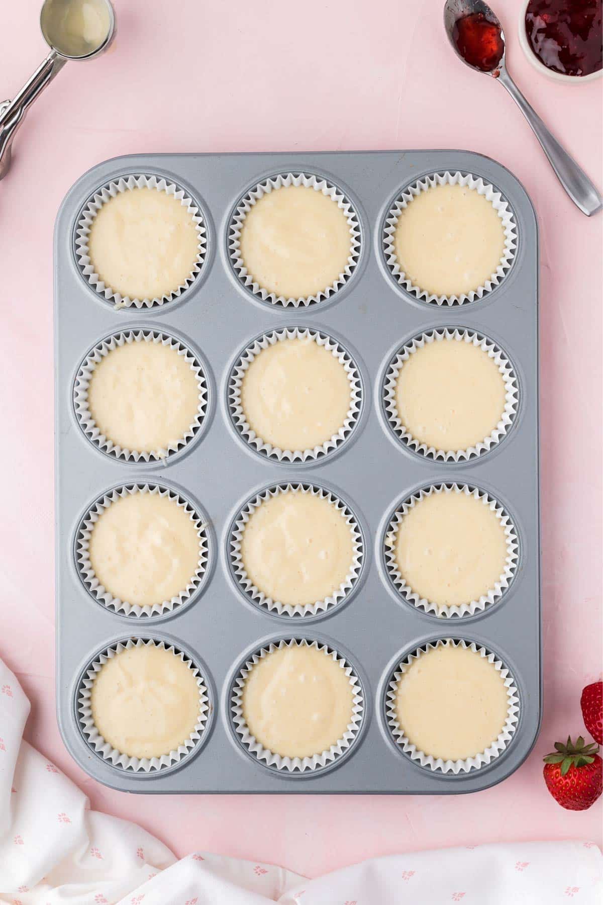 Cupcake pan filled with batter to make strawberry cupcakes.