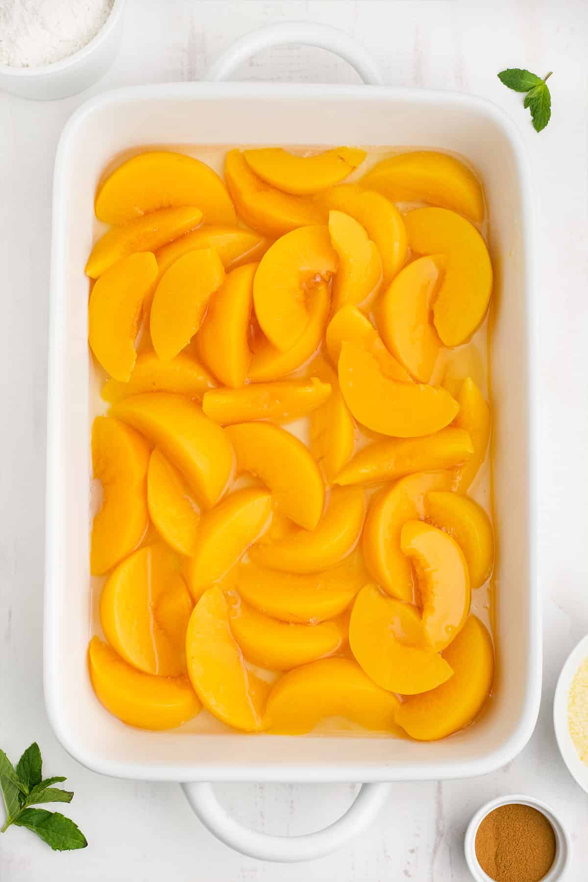 Peaches in the bottom of a baking dish.