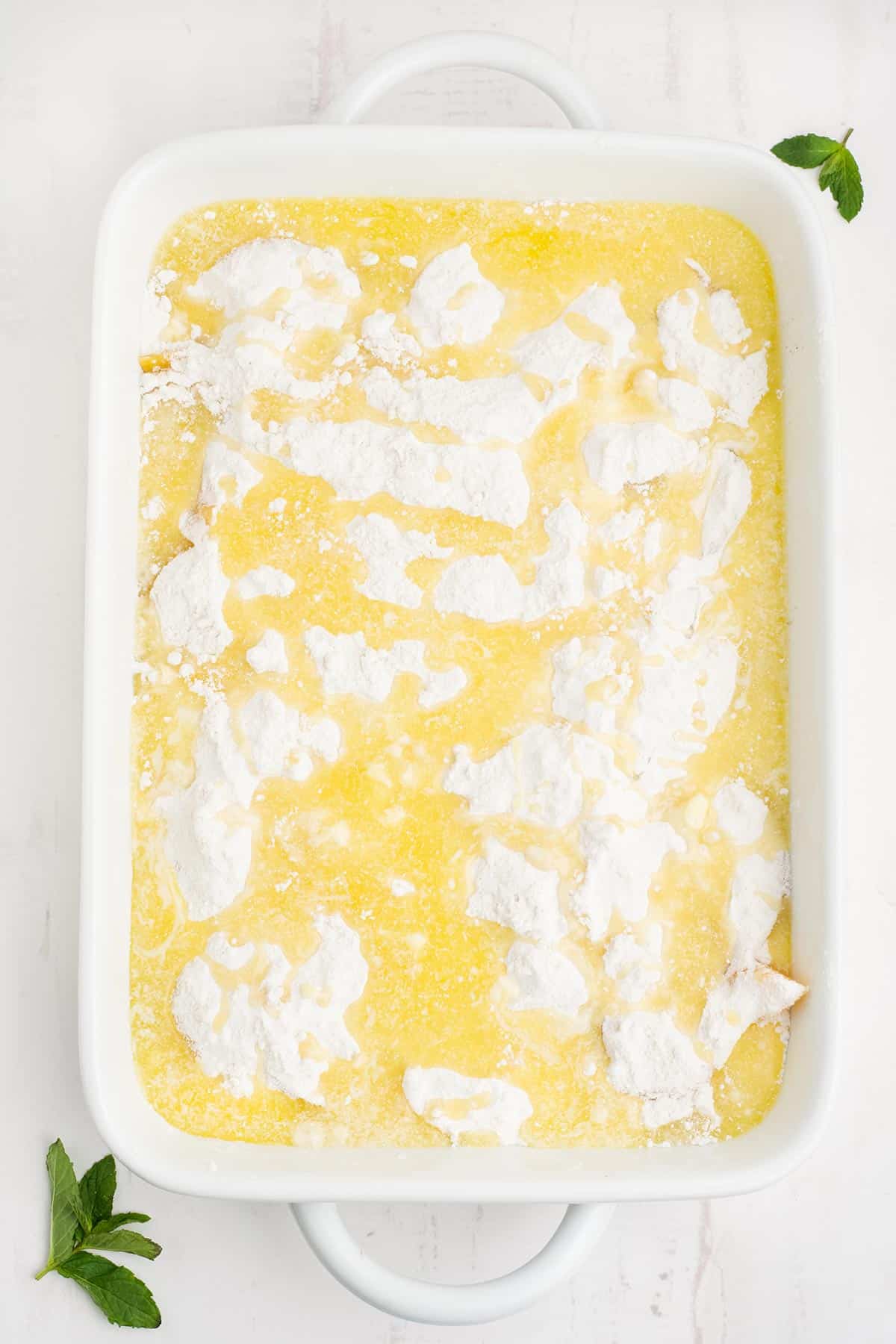 Butter drizzled over the top of the cake mix in the pan.
