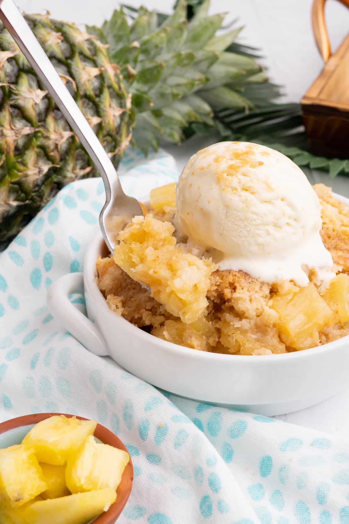 A spoonful of pineapple cake over the bowl of dessert.
