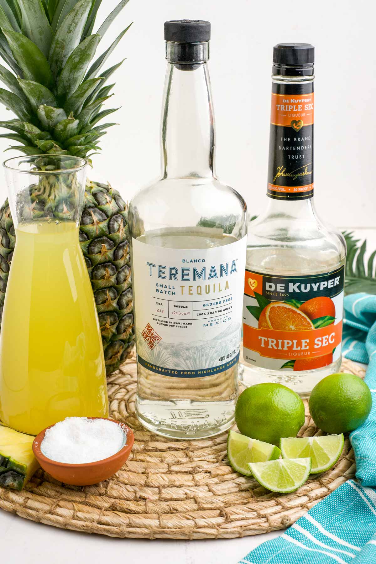 Ingredients to make a pineapple margarita on the table.