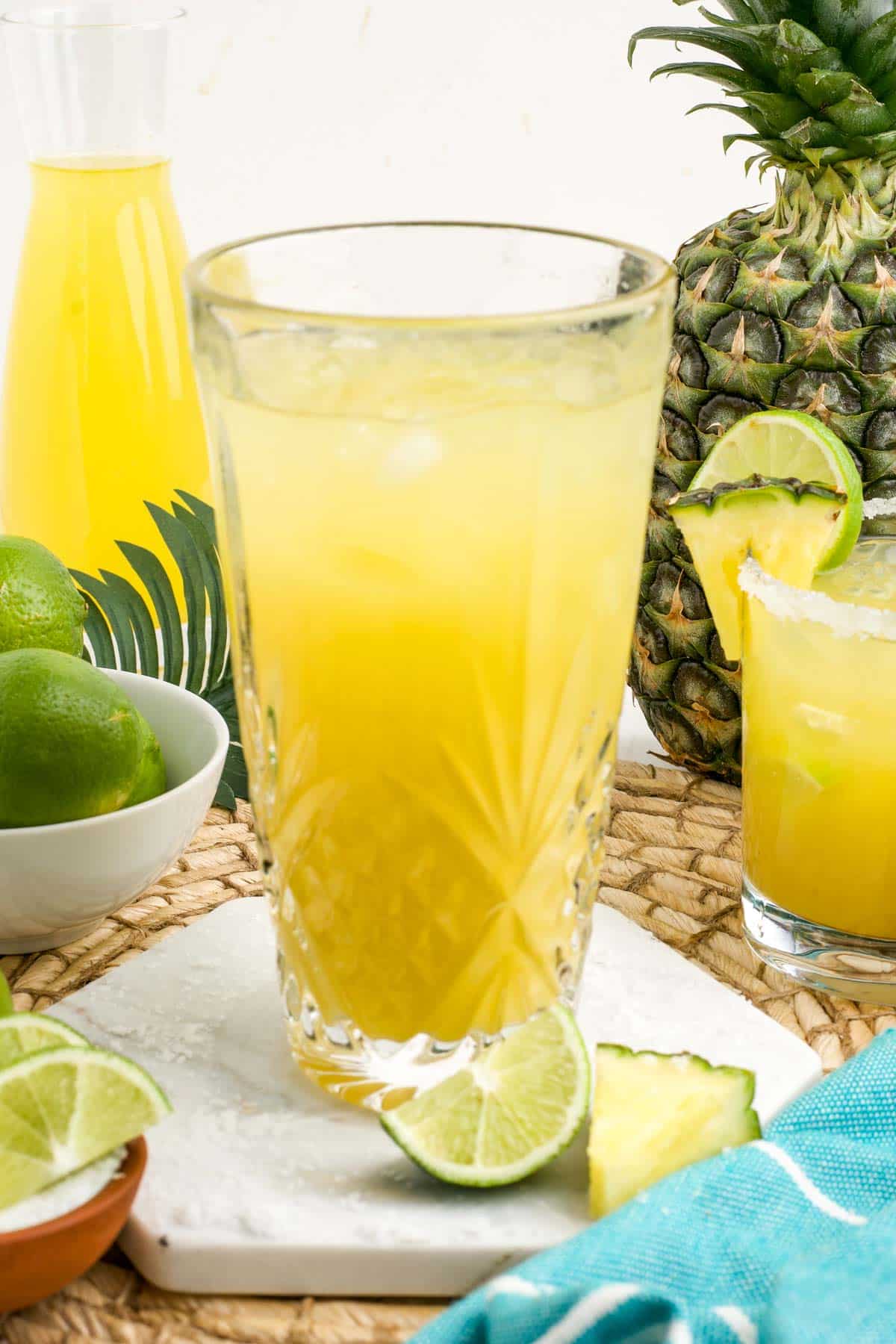 Ingredients to make a pineapple margarita poured into a glass.