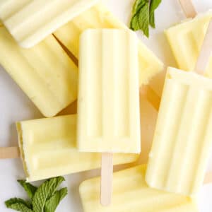 Dole whip popsicles on the table stacked on top in different directions.