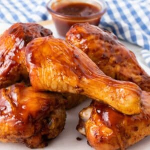 Smoked chicken legs with bbq sauce on a plate.