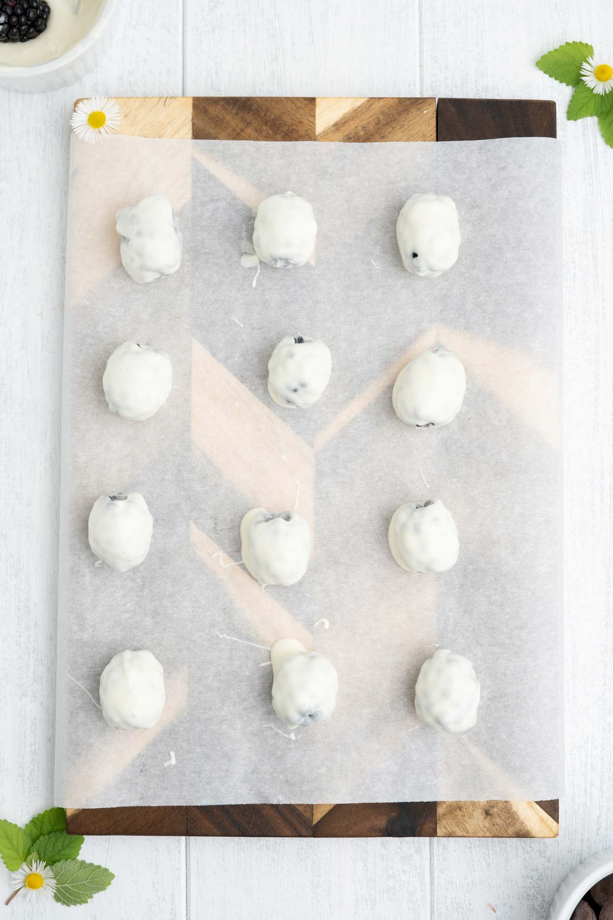 White dipped blackberries on a baking tray with parchment paper.