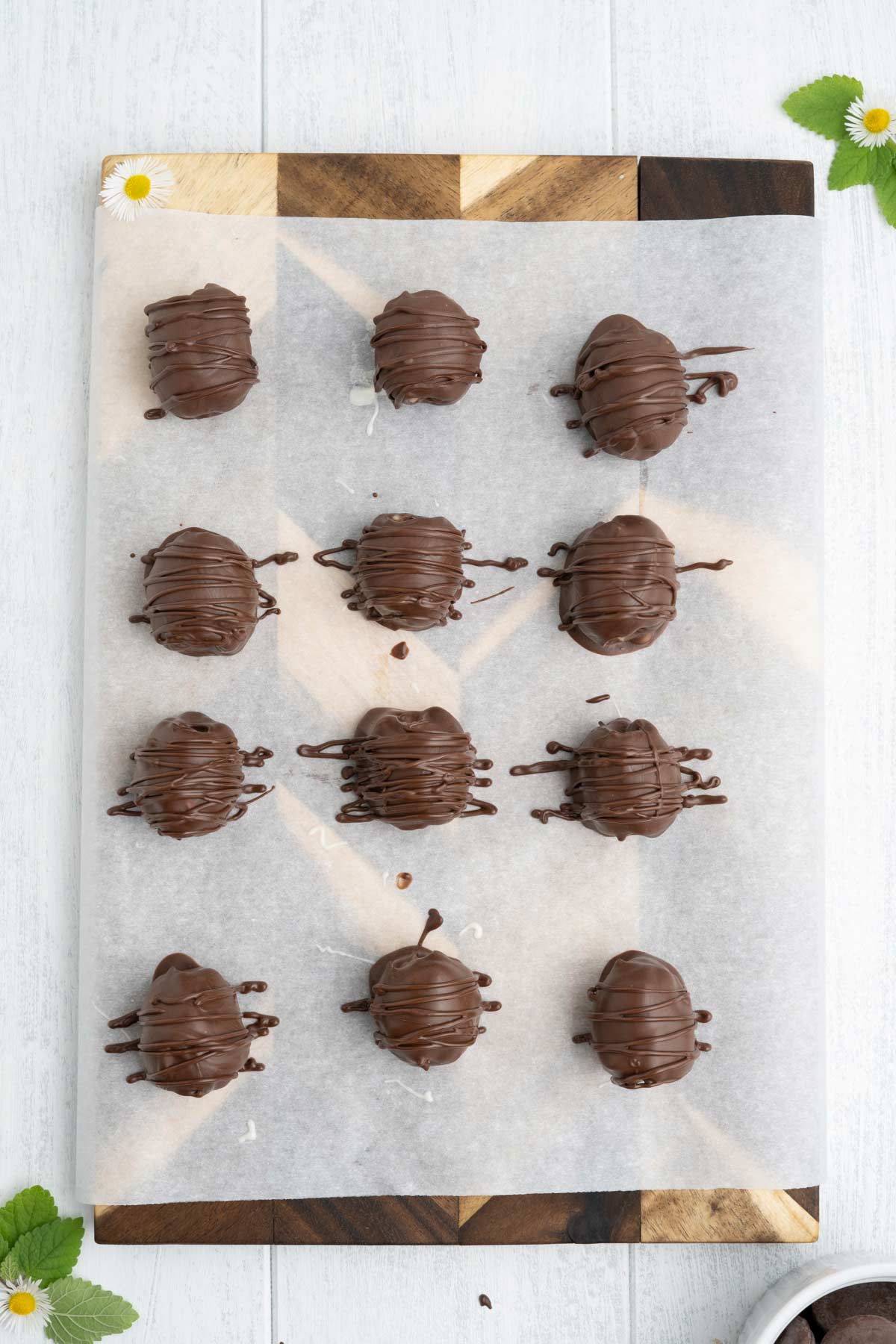 Chocolate covered blackberries on a baking sheet with chocolate drizzled over the top.