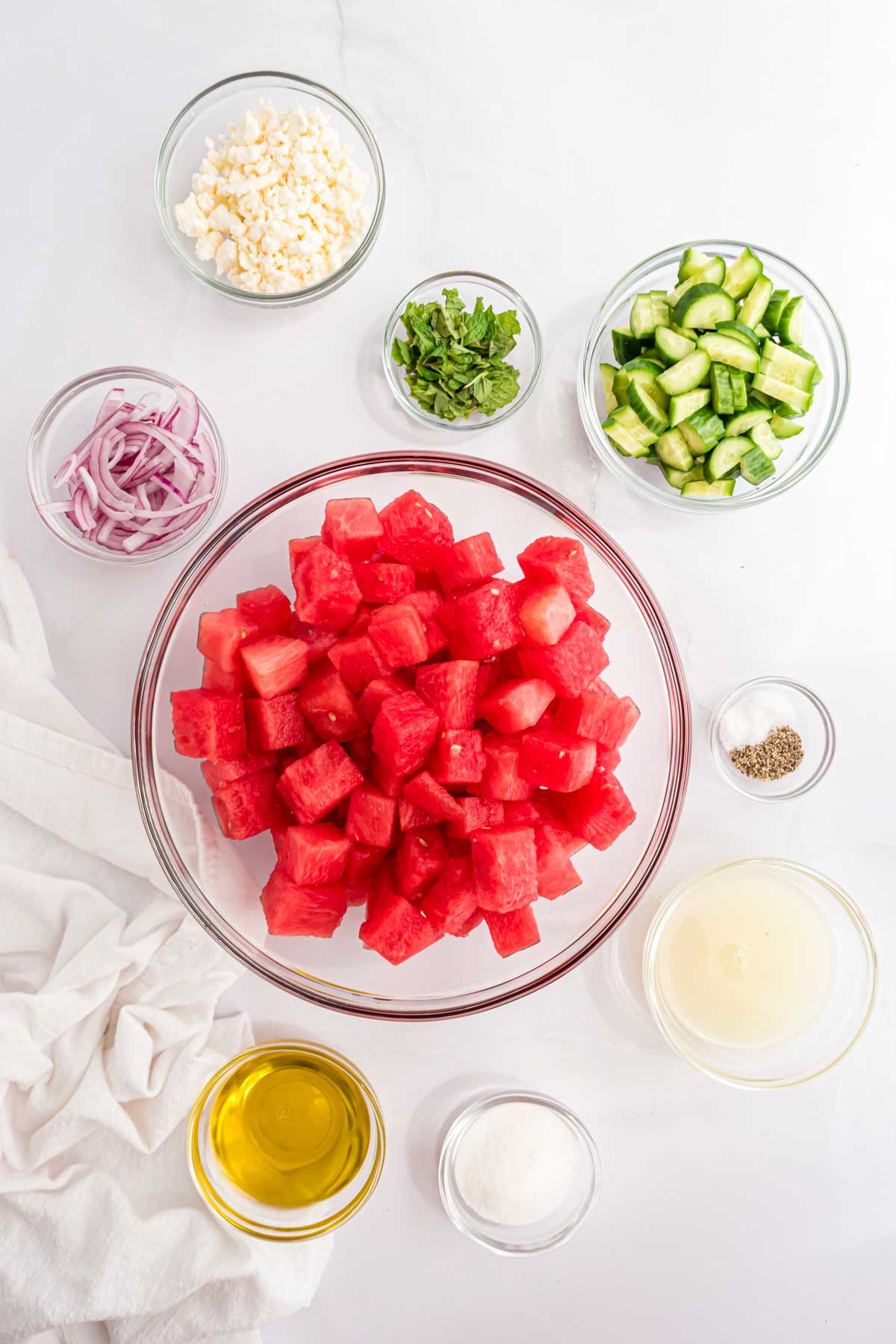 Ingredients to make watermelon feta salad in bowls on the table.