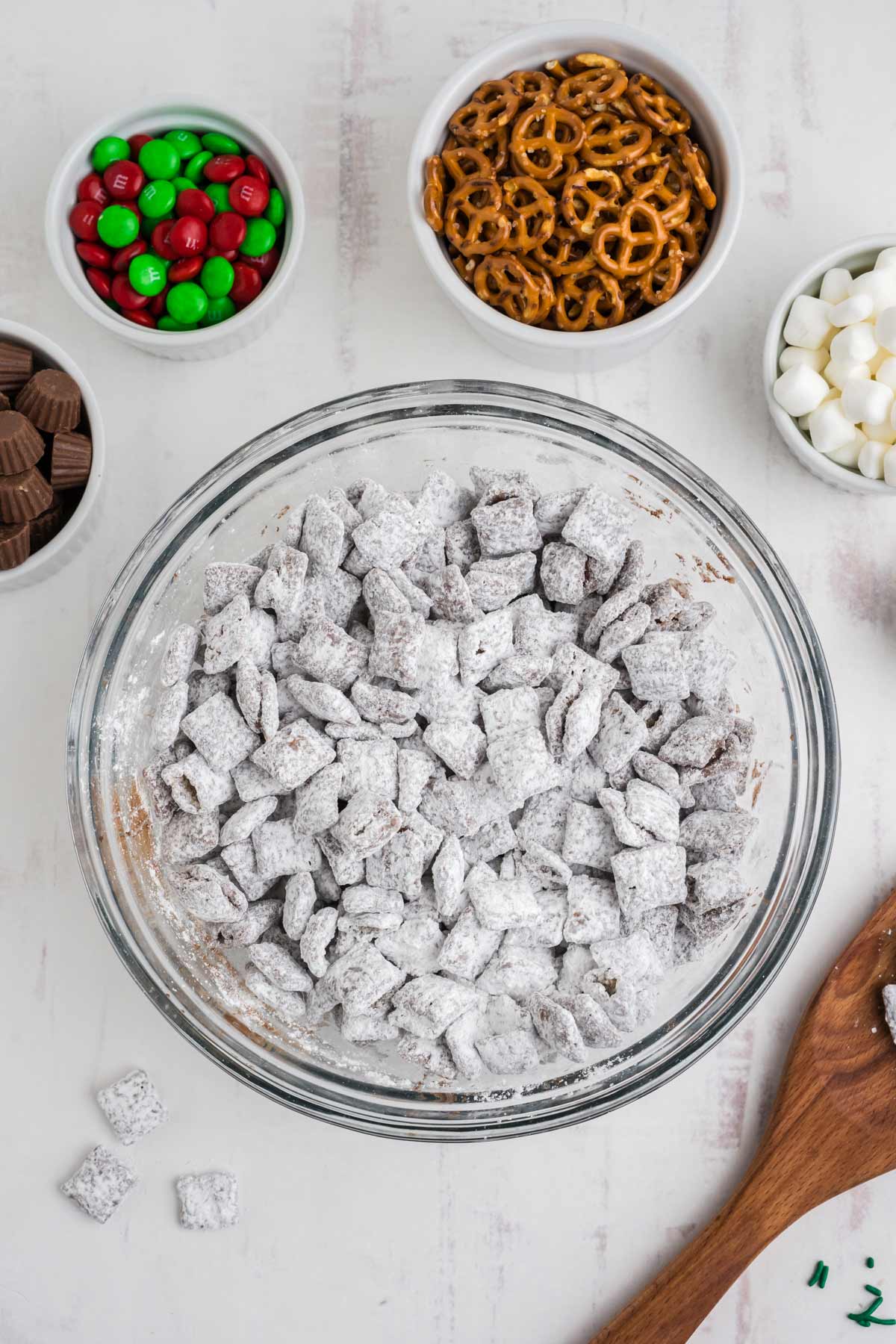 Chocolate covered chex mix coated in powdered sugar in a bowl.