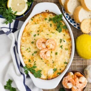Shrimp and cream cheese dip topped with three shrimp in a baking dish.