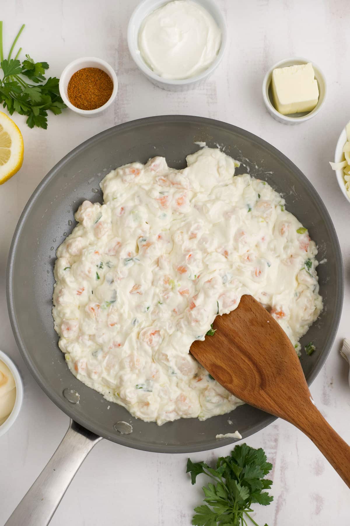 Cream cheese is added to the shrimp dip and mixed together in a skillet.