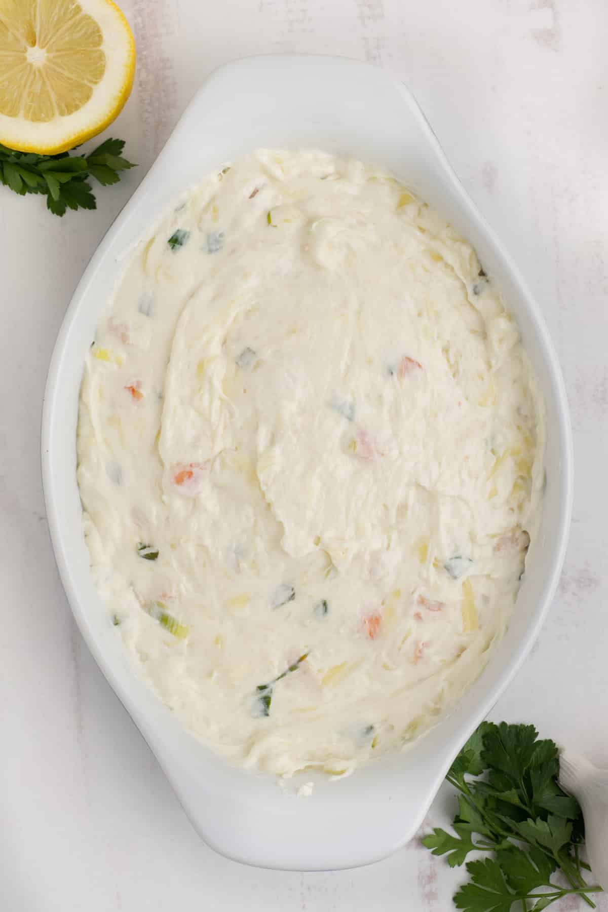 Shrimp and cream cheese dip is transferred to a casserole dish.