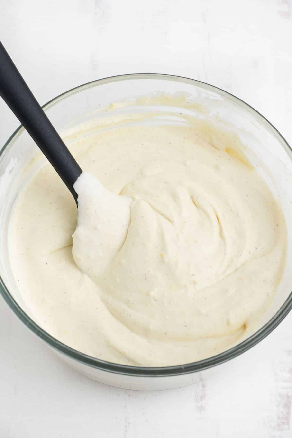 Eggnog dip mixed together with a spatula in the bowl.