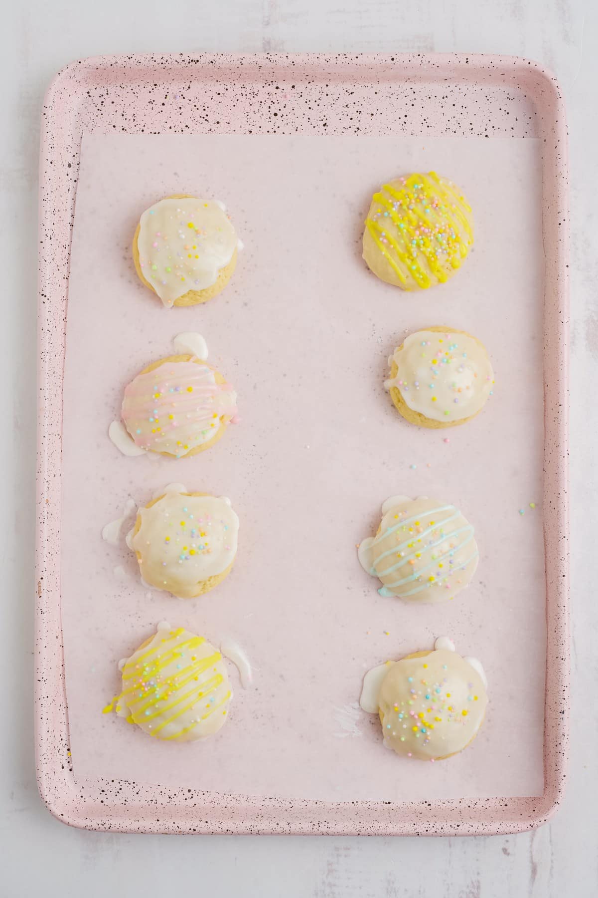 Italian Easter cookies on a baking pan after icing and decorations are added.