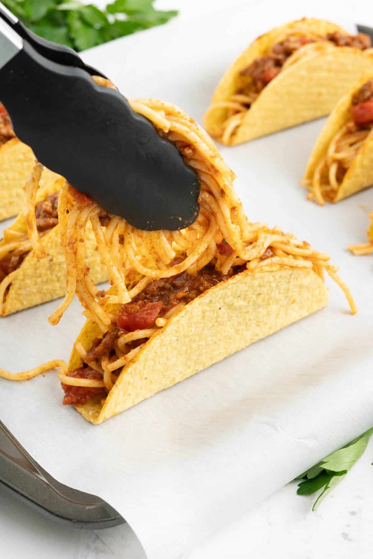 Filling up the tacos with the spaghetti filling.