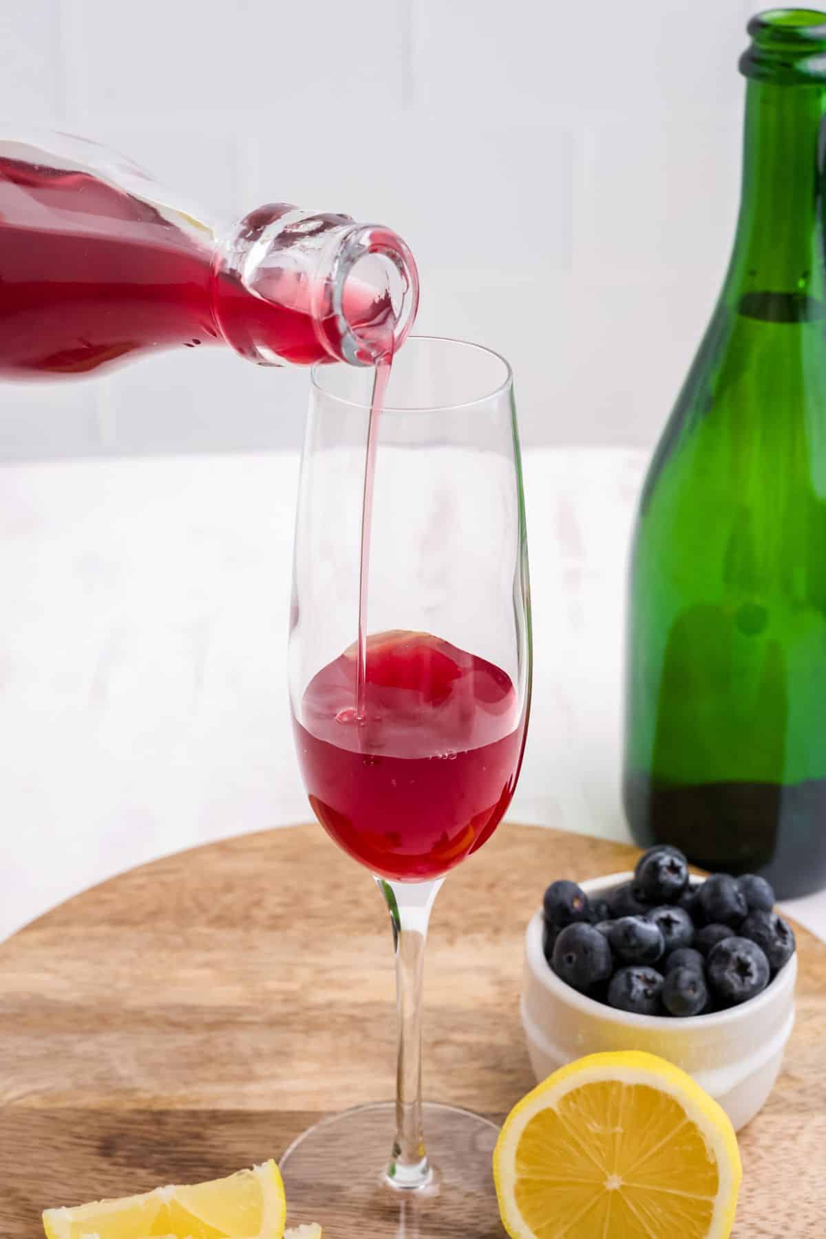 Pouring the blueberry juice into a glass. 