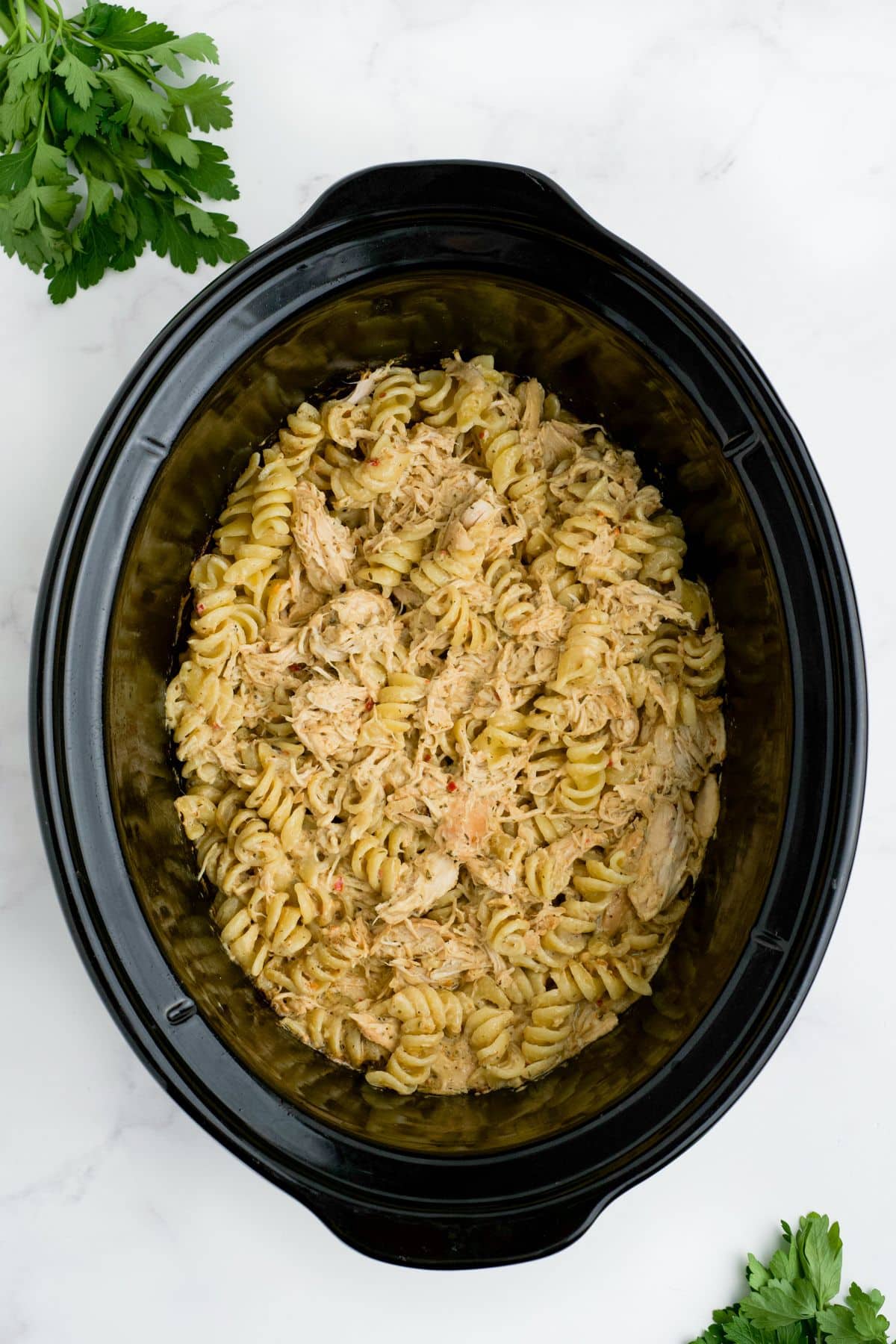 Pasta stirred into the chicken and sauce.