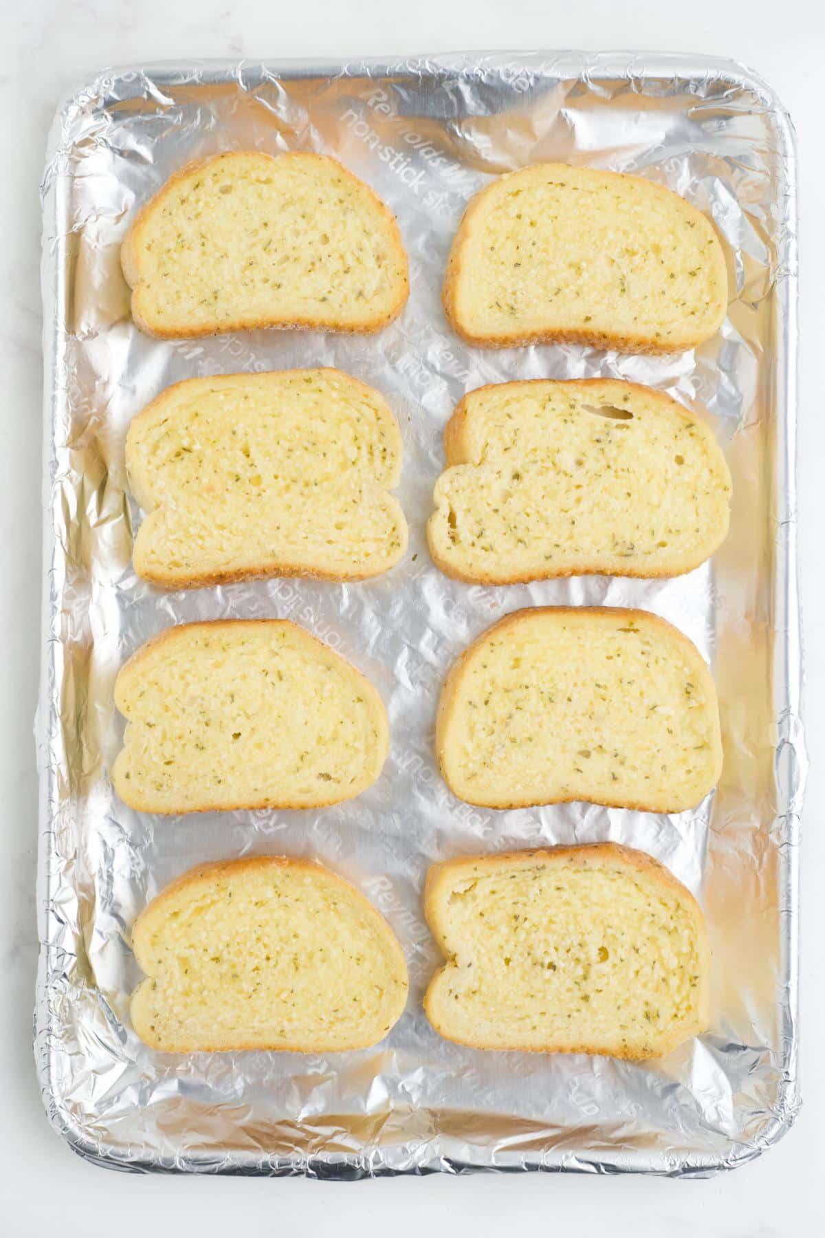 Texas toast laid out on a baking tray.