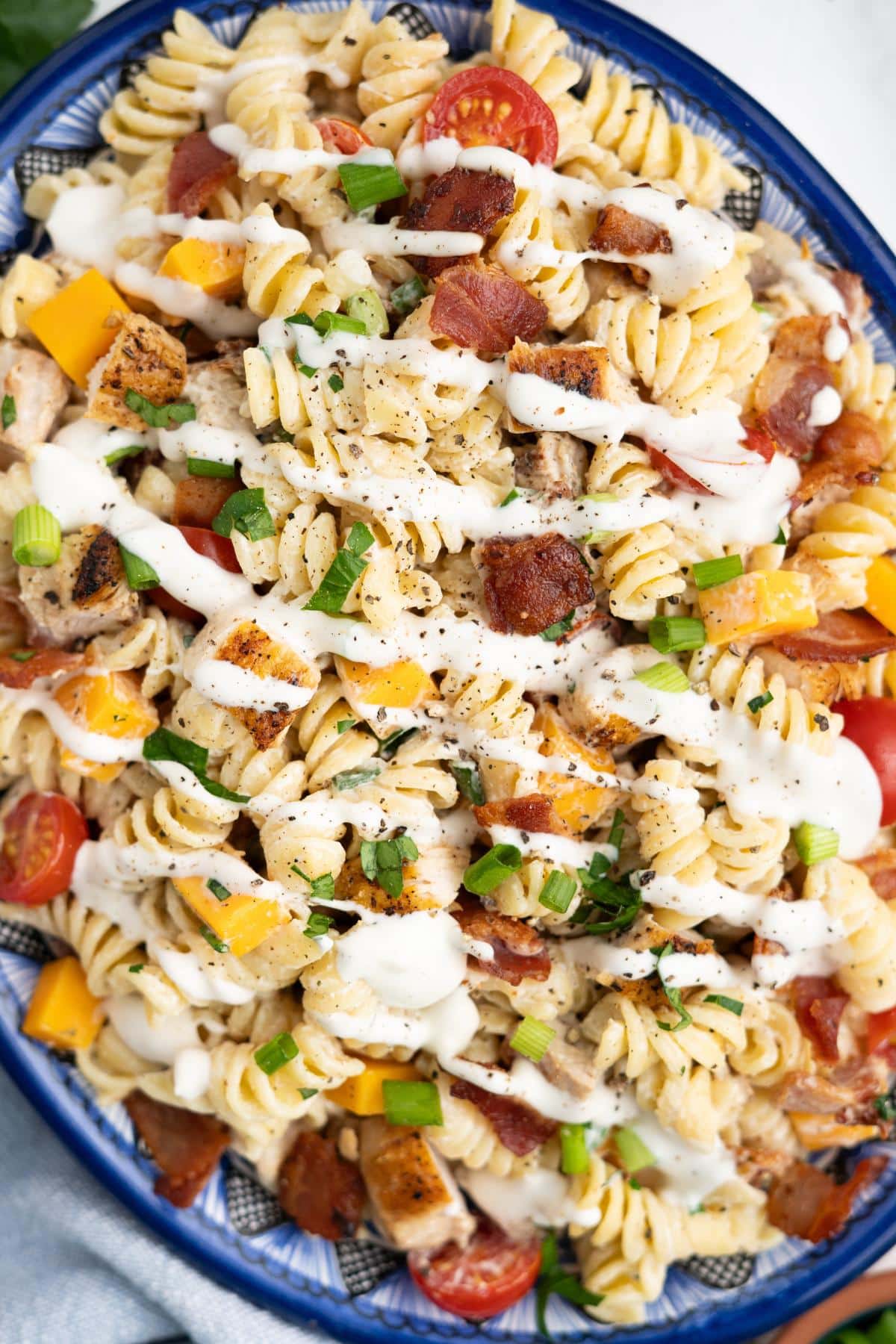 Chicken bacon ranch pasta salad on a blue rimmed platter.