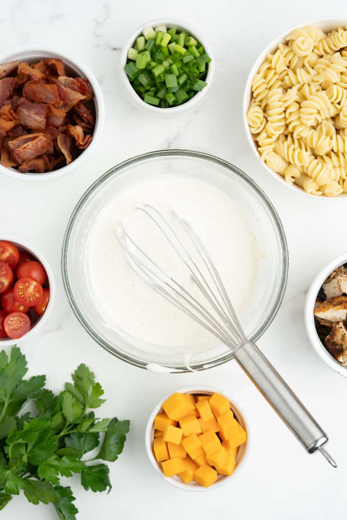 Mixing the ranch dressing in a bowl with a whisk resting on the side.