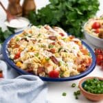 Chicken bacon ranch pasta salad served up on an oval plate garnished with parsley.