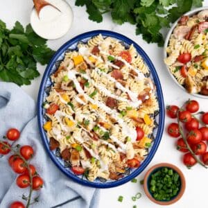 An oval platter of chicken bacon ranch pasta salad on a table.