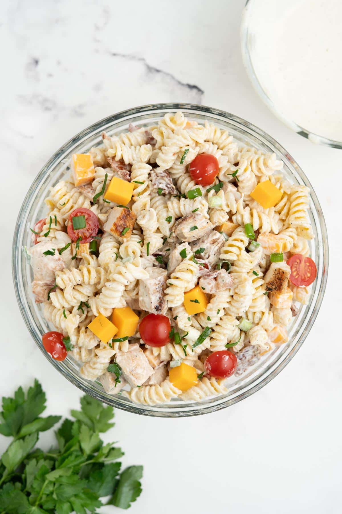 Chicken bacon ranch pasta salad mixed in a glass mixing bowl.