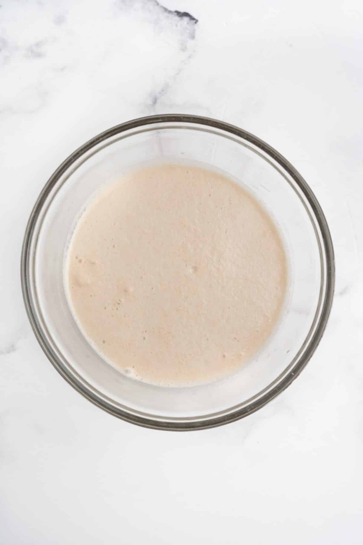 Yeast and warm water in a glass bowl to activate the yeast.