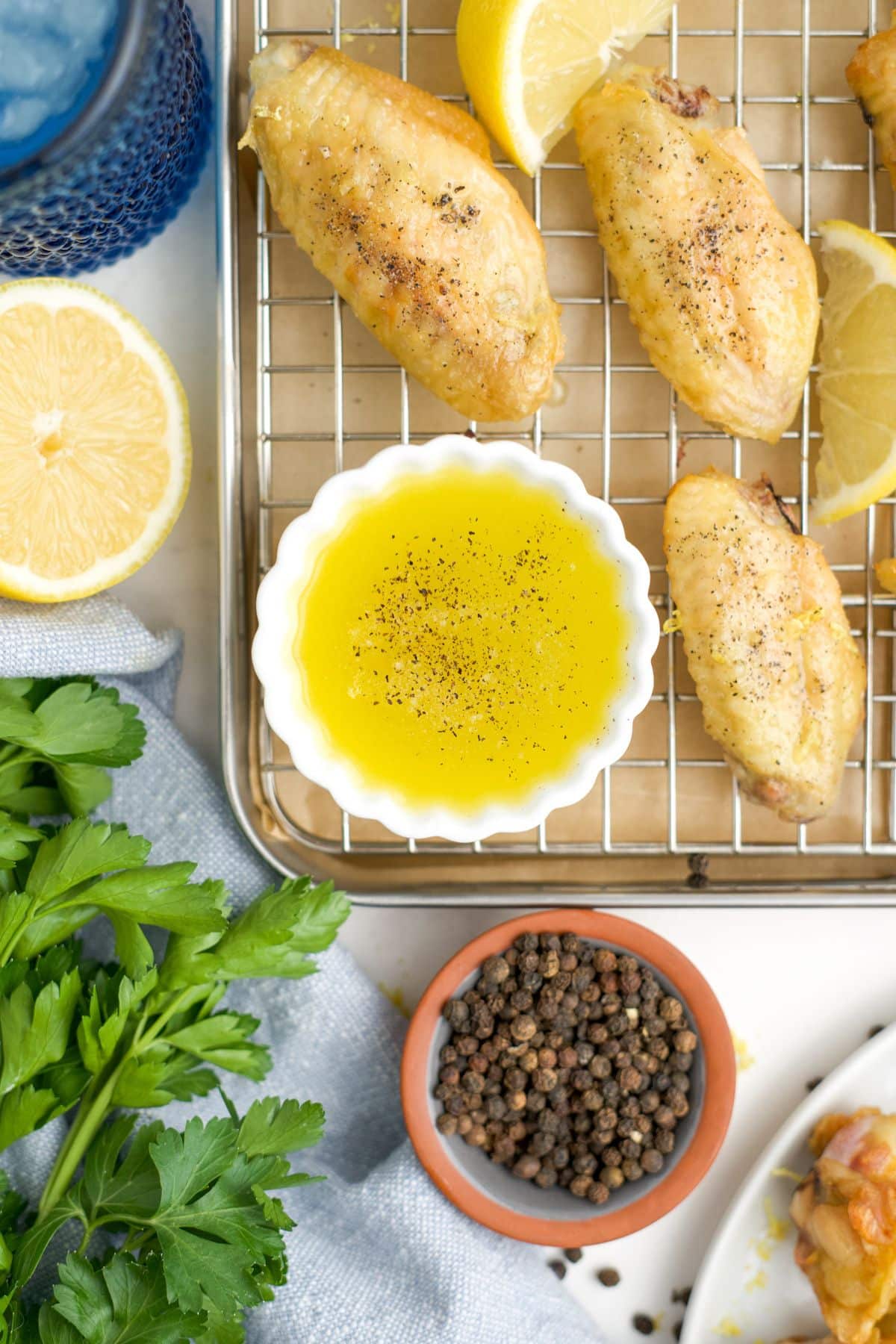 A white bowl of lemon pepper sauce for wings next to other ingredients.