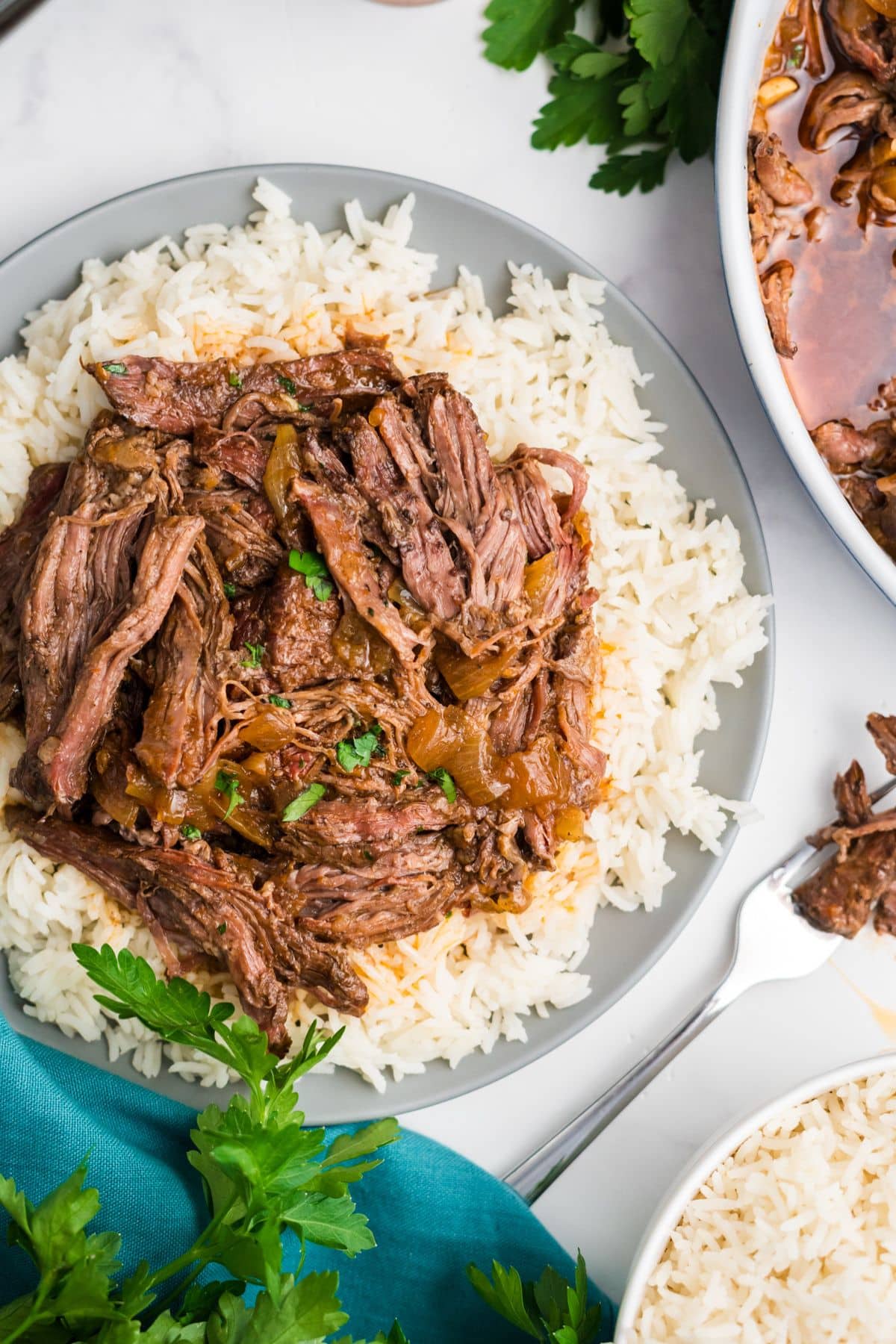 A plate of rice topped with slow cooker skirt steak.