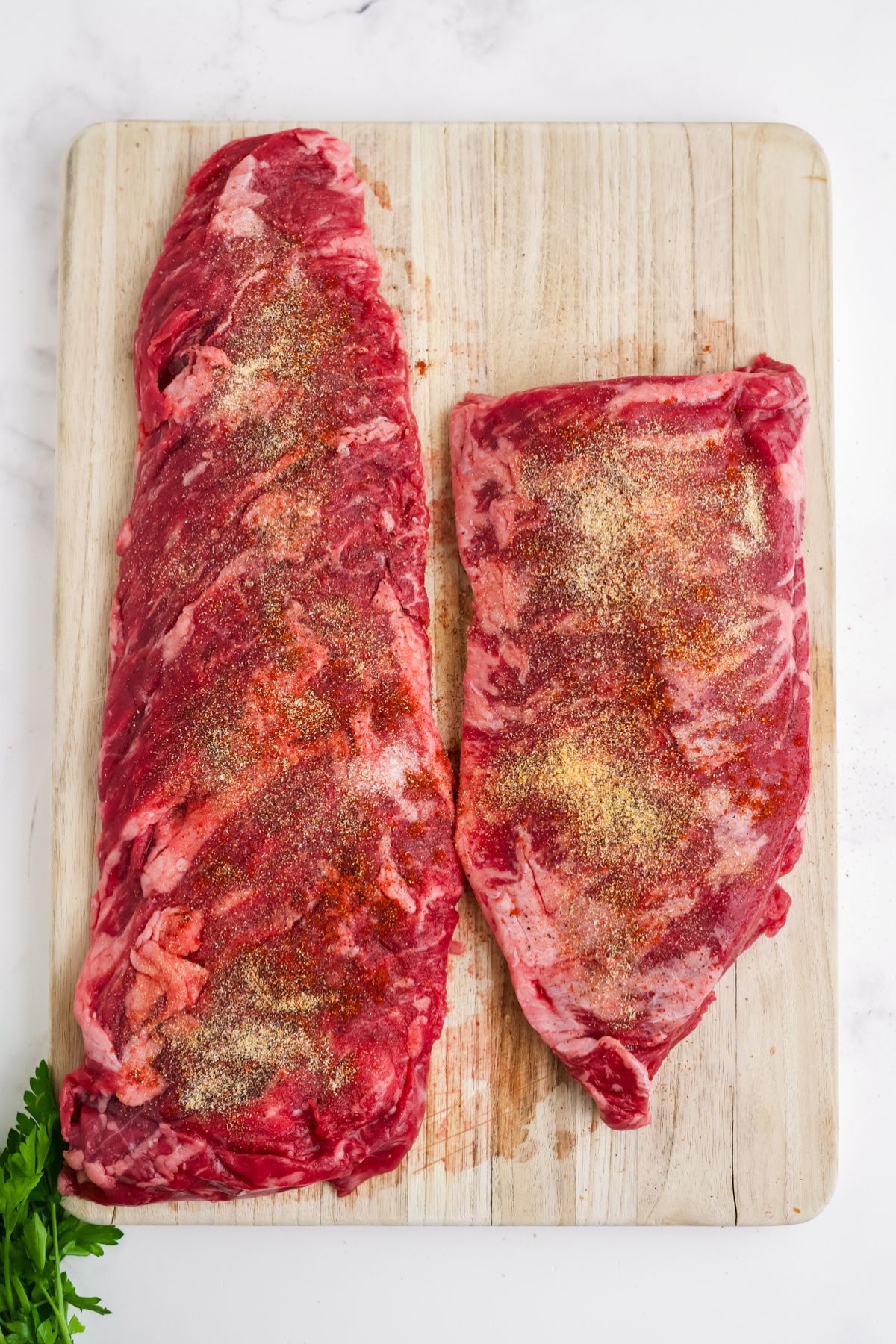 Skirt steak seasoned on a cutting board.