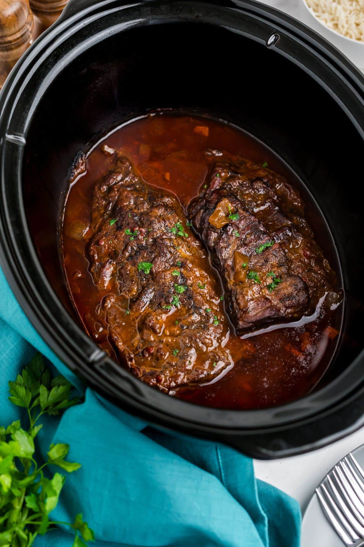 Cooked skirt steak in a slow cooker.
