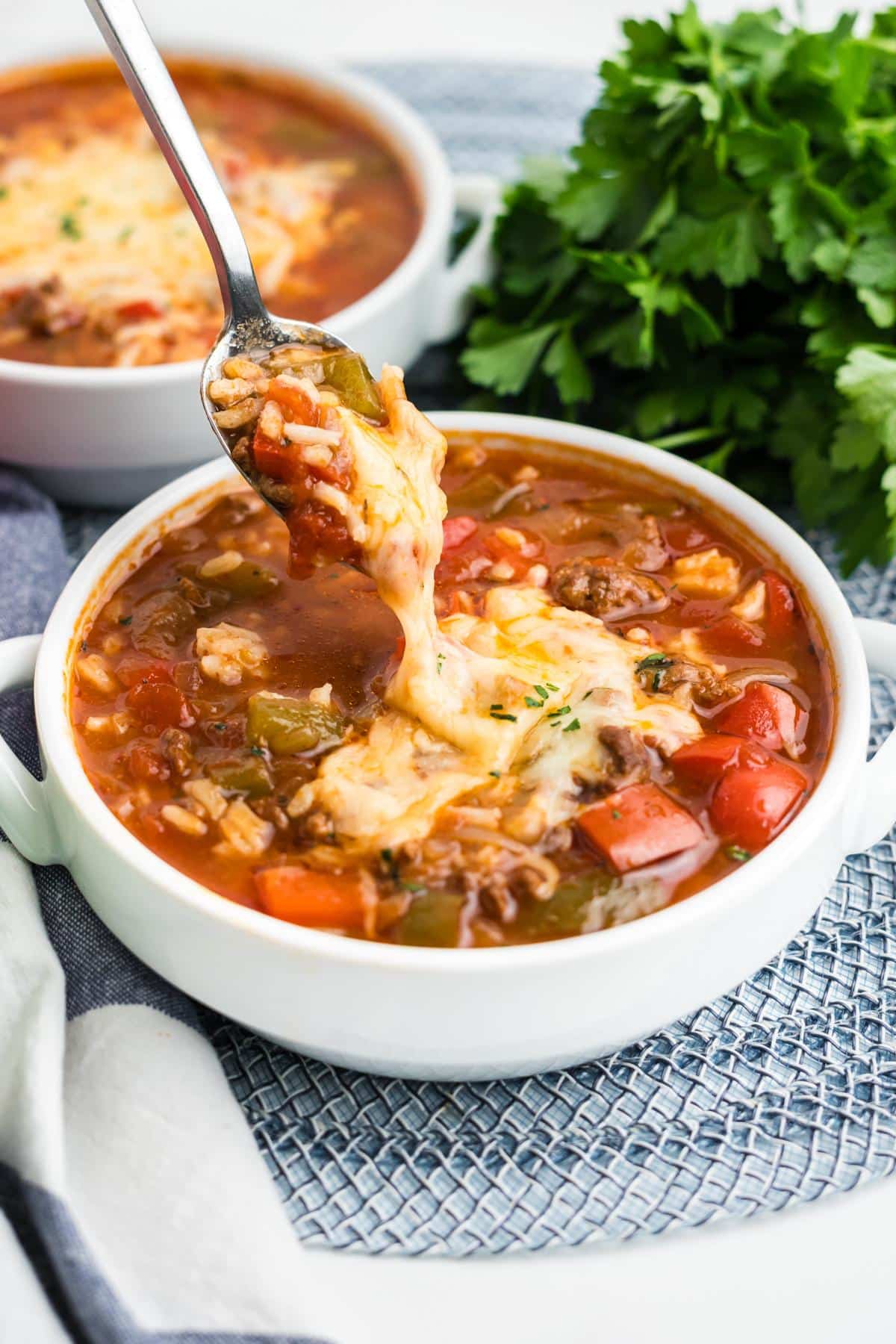 A spoon lifting up a bite of slow cooker stuffed pepper soup.