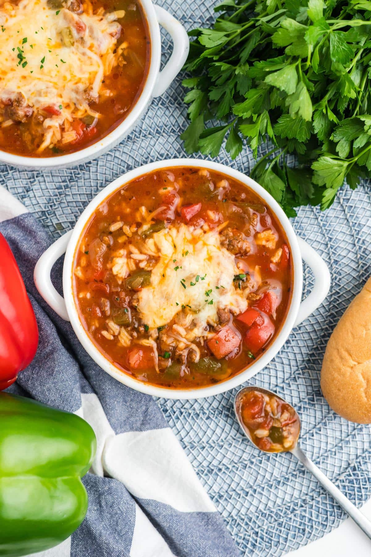 A bowl of crockpot stuffed pepper soup topped with melted cheese.
