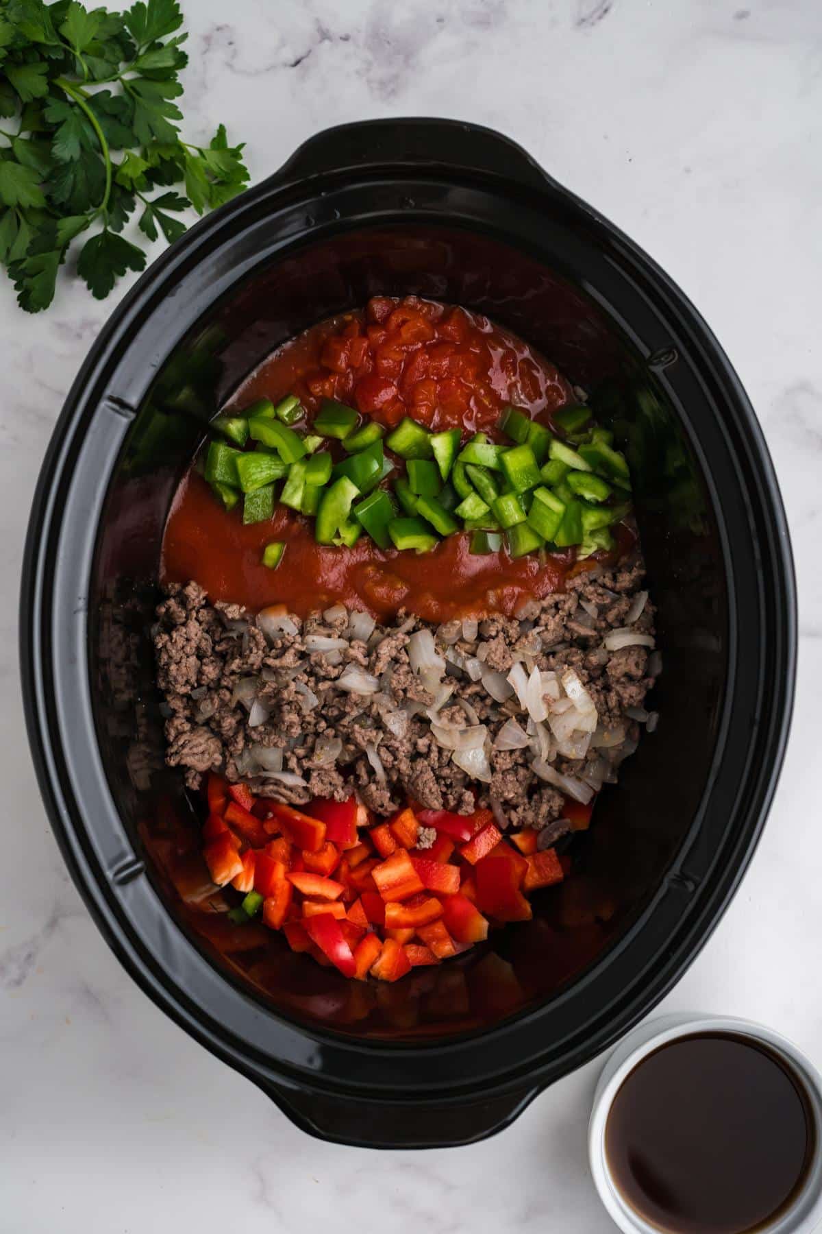 Ingredients added to a slow cooker.