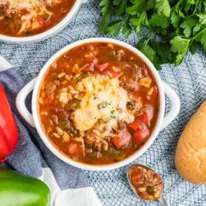 A bowl of slow cooker stuffed pepper soup topped with melted cheese.
