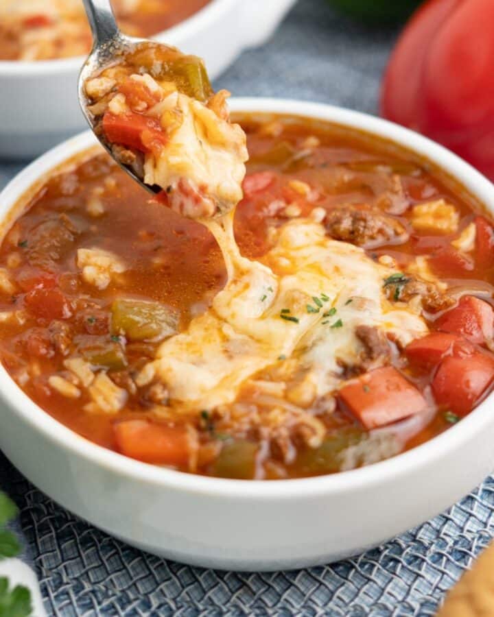 A spoon lifting up a bite of slow cooker stuffed pepper soup.