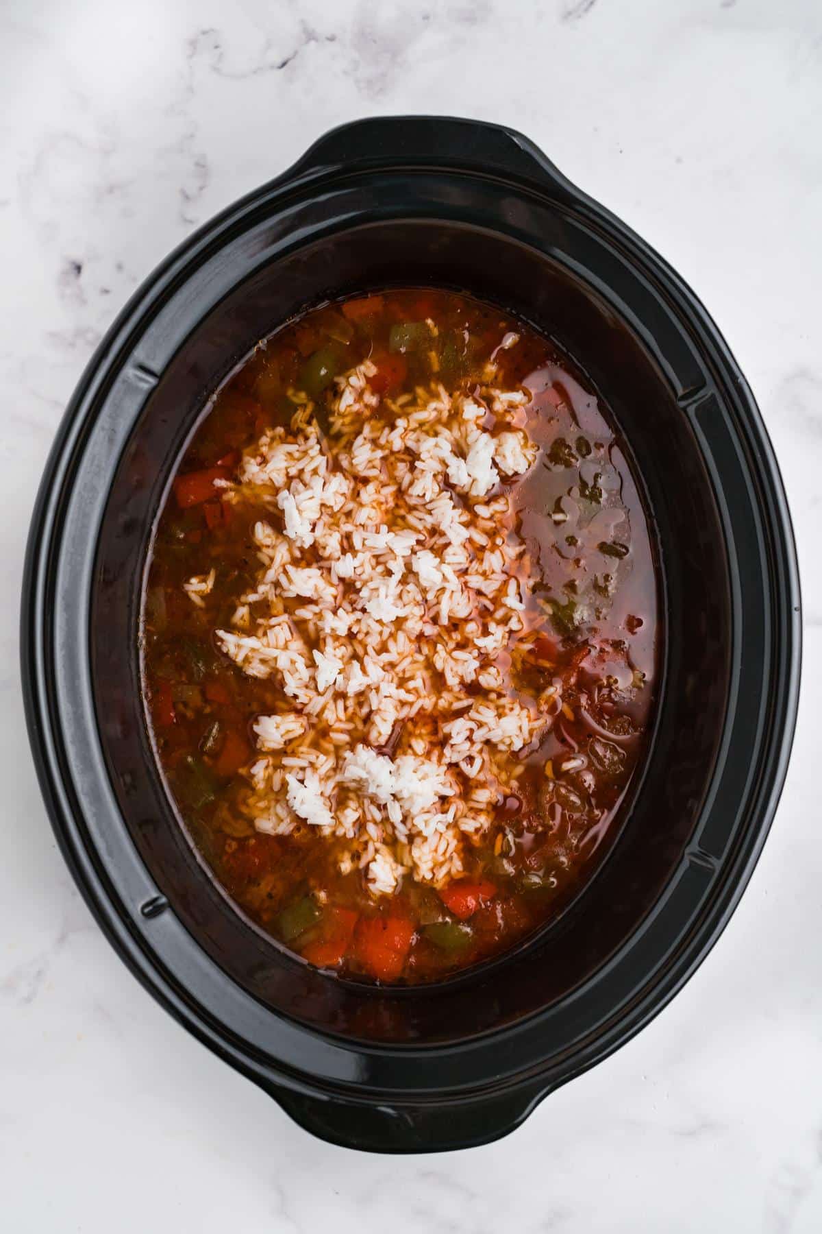 Rice added to stuffed pepper soup in the crockpot.