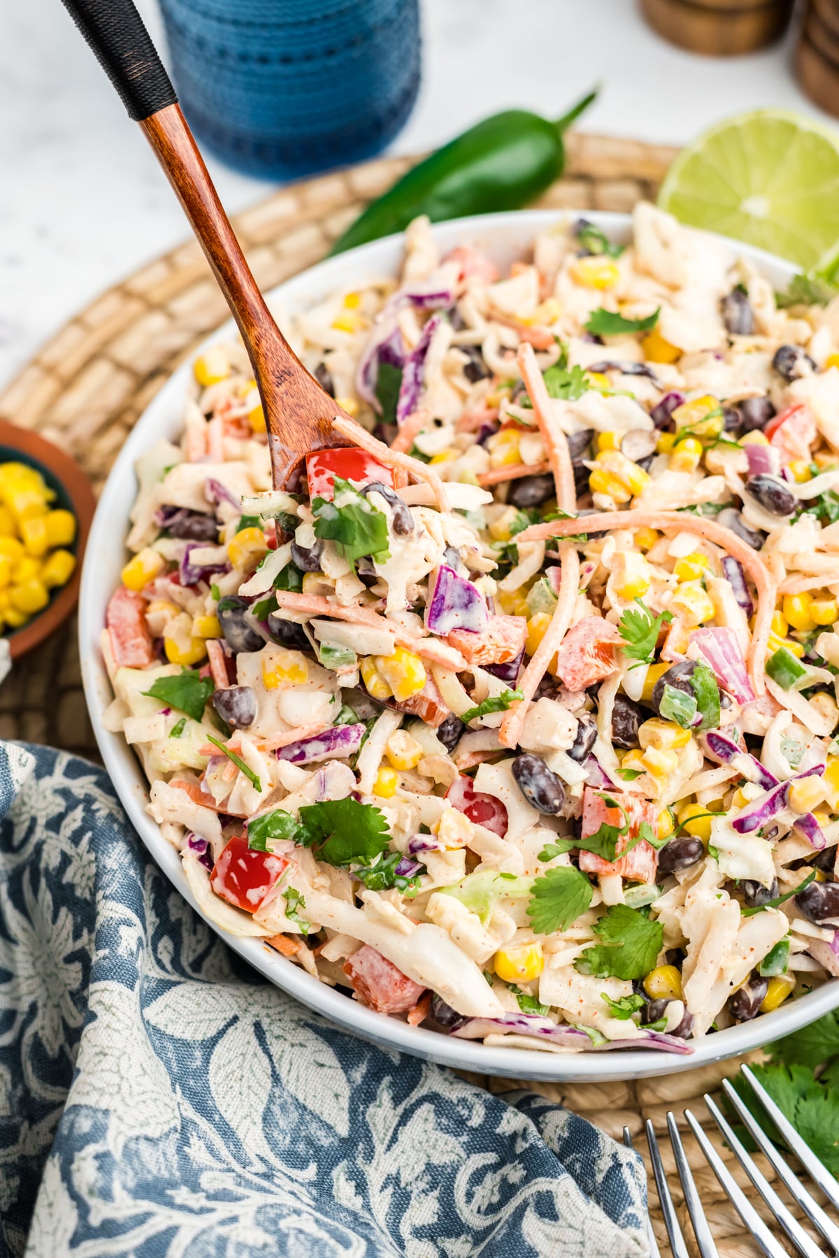 A serving spoon scooping up a serving of southwest coleslaw.