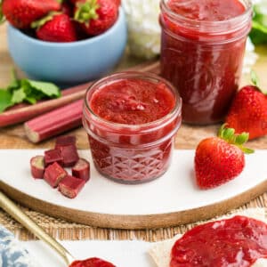 Strawberry Rhubarb Jam in a small jar with ingredients around the jar.