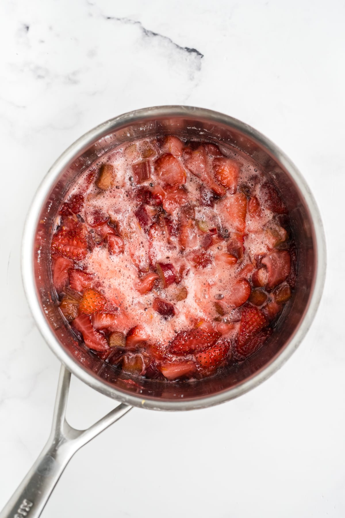 An image of strawberry rhubarb jam cooking in a pan.